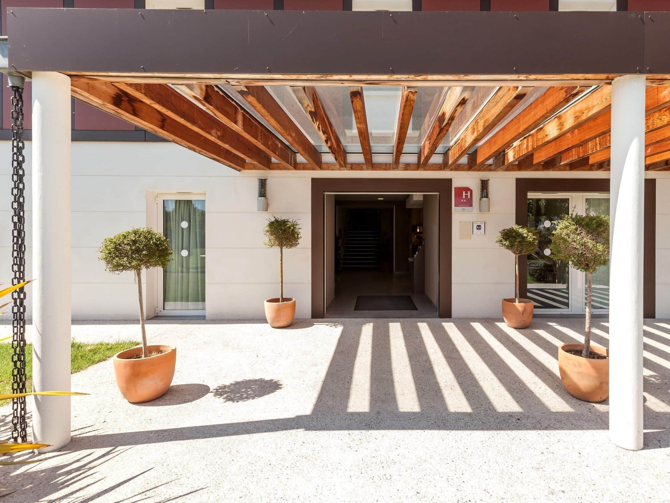 Entrée de l'hôtel sous la pergola